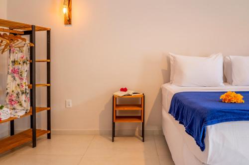 a bedroom with a bed and a side table at Casa Suiça Brasileira in Jericoacoara