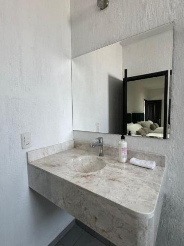 a bathroom counter with a sink and a mirror at Suite Los Angeles in Tecozautla