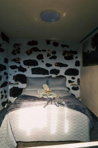 ein Schlafzimmer mit einem Bett mit Kühen an der Wand in der Unterkunft Los Amantes de la naturaleza. in Salão