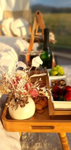 a table with two dishes of fruit and a bottle of wine at The Hunter Valley Star Gazing BubbleHotel in Mulbring