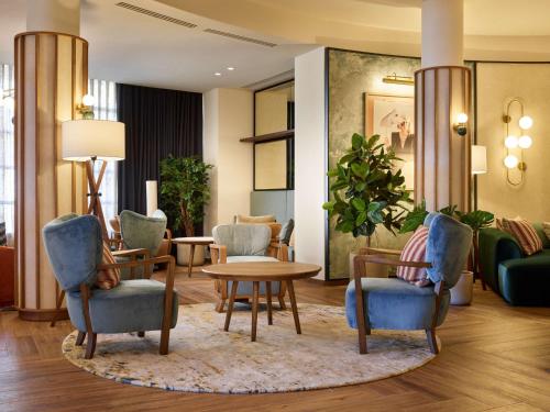 a lobby with chairs and a table and a couch at Radisson Blu Hotel Marseille Vieux Port in Marseille