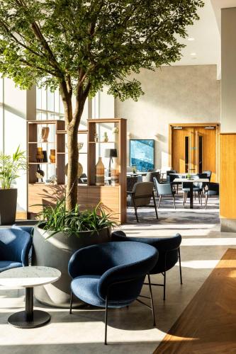 a lobby with tables and chairs and a tree at Radisson Blu Hotel, Durham in Durham