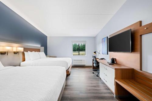 a hotel room with two beds and a flat screen tv at Best Western Niantic - New London, Mystic Area in Niantic
