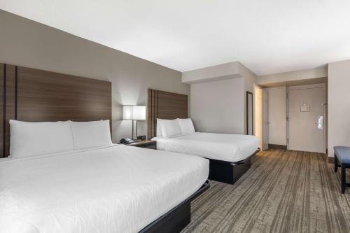a hotel room with two beds and a desk at Best Western Plus Laurel in Laurel