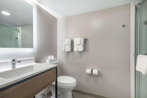 a white bathroom with a toilet and a sink at Best Western Plus Laurel in Laurel