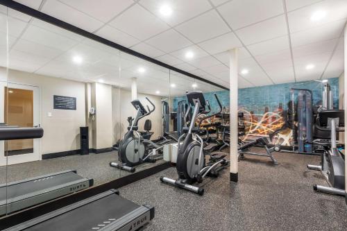 a gym with cardio equipment and a mural of a city at Best Western Plus Laurel in Laurel