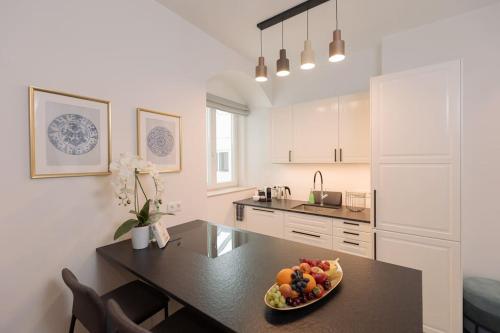 a kitchen with a table with a bowl of fruit on it at Suite Nr 3 - J26 LUXURY APARTHOTEL, Jauniela 26 Old Riga - Great View & Top Location - 2 Bedrooms - 80 m2 in Rīga