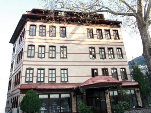 un edificio blanco alto con muchas ventanas en Kadi Konagi Thermal Hotel, en Bursa