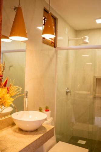 a bathroom with a sink and a glass shower at Casa Suiça Brasileira in Jericoacoara