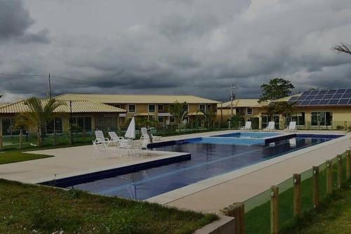 a swimming pool with chairs and tables and a building at APT Completo - Ar-condicionado, Wi-FI, piscina, garagem, portaria - aconchegante in Caruaru