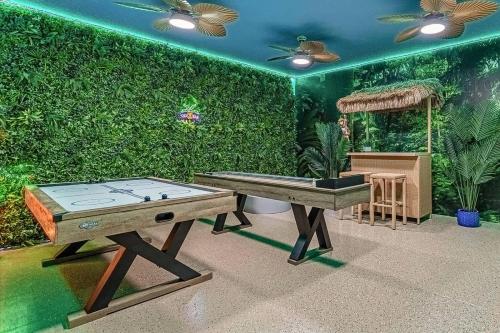 a room with a ping pong table and an aquarium at Upstay Lakeside 10 Bedroom Home with Pool Private Cinema & Game Room in Kissimmee