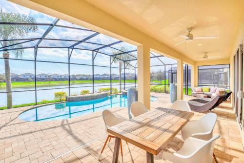 an indoor patio with a table and chairs and a pool at Upstay Lakeside 10 Bedroom Home with Pool Private Cinema & Game Room in Kissimmee