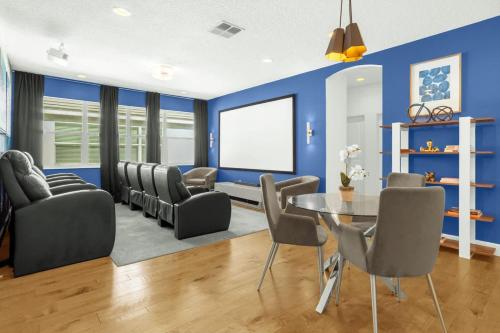 a living room with blue walls and a table and chairs at Upstay Lakeside 10 Bedroom Home with Pool Private Cinema & Game Room in Kissimmee