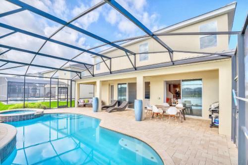 a home with a swimming pool and a house at Upstay Lakeside 10 Bedroom Home with Pool Private Cinema & Game Room in Kissimmee