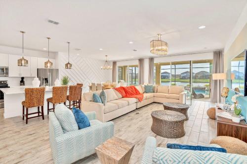a living room with a couch and a kitchen at Upstay Lakeside 10 Bedroom Home with Pool Private Cinema & Game Room in Kissimmee