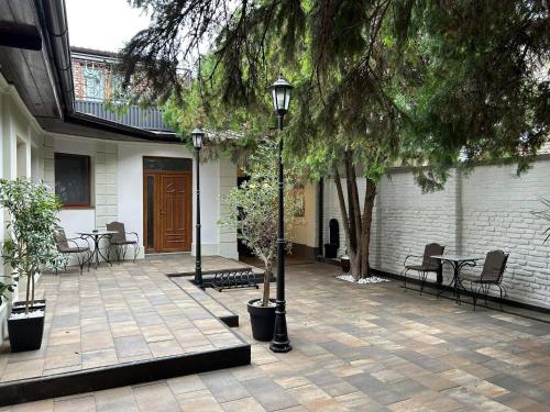 a courtyard with tables and chairs and a tree at Face 2 Center SUBOTICA in Subotica