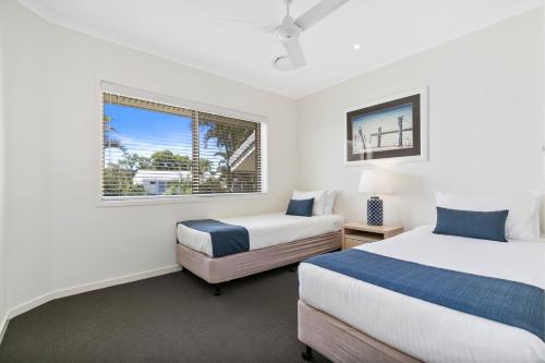 a bedroom with two beds and a window at Culgoa Point Beach Resort in Noosa Heads