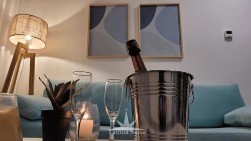 una botella de vino en un cubo sobre una mesa con copas en Departamento 318 en complejo premiun de Pinamar Norte, en Pinamar