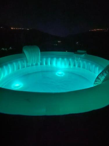 a green glow in the dark hot tub at night at L'Antica Quercia B&B in CastellʼUmberto