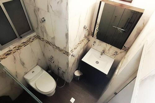 ein Badezimmer mit Toilette, Waschbecken und Spiegel in der Unterkunft Moderno y Bonito Apto en Sebucan, Caracas in Caracas