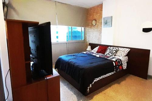 ein Schlafzimmer mit einem Bett und einem Flachbildfernseher in der Unterkunft Moderno y Bonito Apto en Sebucan, Caracas in Caracas