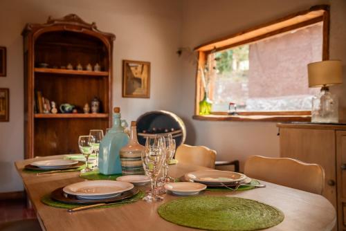 a wooden table with plates and glasses on it at San Ignacio Estancia Andina in El Challao