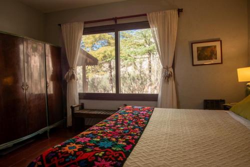 a bedroom with a bed and a large window at San Ignacio Estancia Andina in El Challao