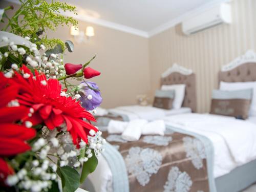 a hotel room with a bed and a bouquet of flowers at Kadi Konagi Thermal Hotel in Bursa