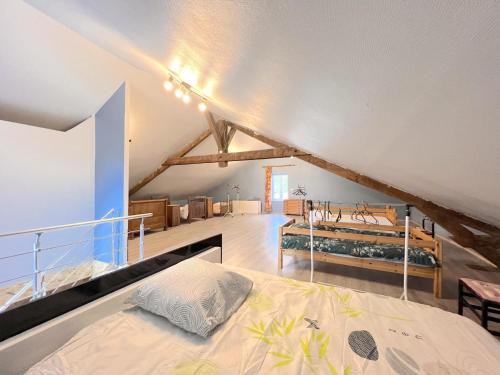 a bedroom with a large bed in a attic at La Usine du Charme in Saint-Menges