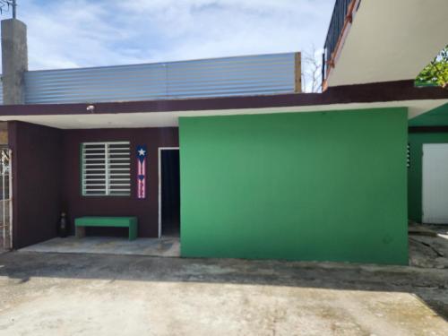 a green wall in front of a building at Nice place to relax level I in Fajardo
