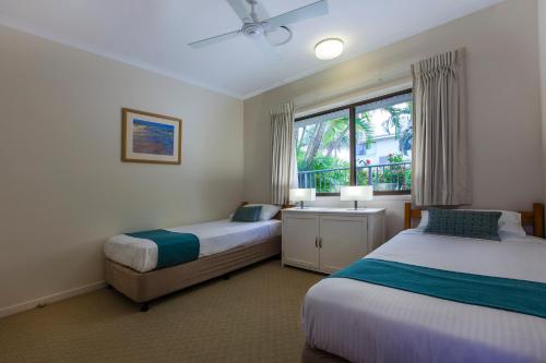 a bedroom with two beds and a window at Culgoa Point Beach Resort in Noosa Heads