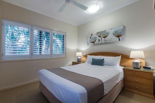 a bedroom with a large bed and two windows at Culgoa Point Beach Resort in Noosa Heads