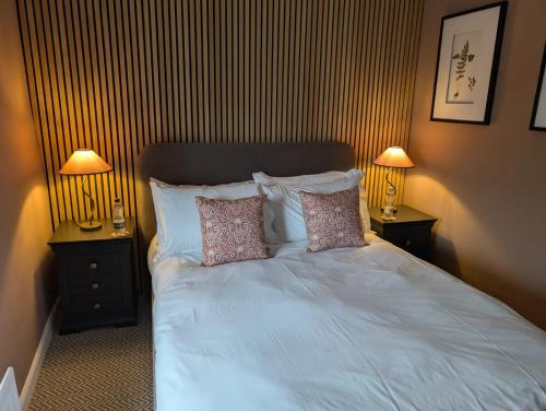 a bedroom with a white bed with two night stands at The Swinside Inn in Keswick