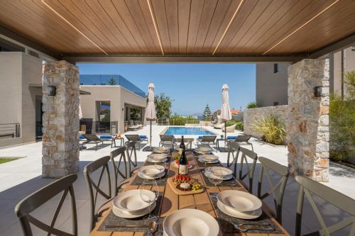an outdoor dining area with a table and chairs at Imperium Luxury Villas-Sauna, Jacuzzi, Heated Pool & Gym-Chania in Kato Galatas