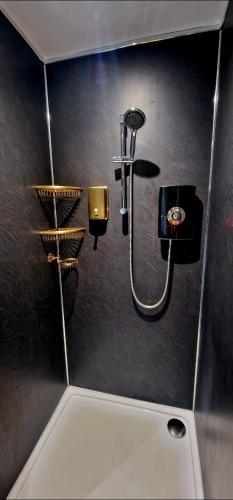 a bathroom with a shower on a wall at Liverpool House Near City Centre in Liverpool