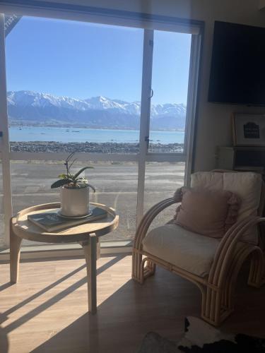 a living room with a table and a chair and a window at Kaikoura Seaside lodge in Kaikoura