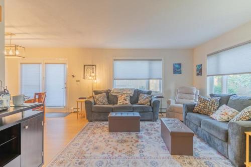 a living room with two couches and a table at The Westside Garay Townhome in Fairbanks