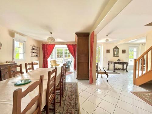 une salle à manger et un salon avec une table et des chaises dans l'établissement Villa Champfleury, à 50 m de la plage!, à Réville