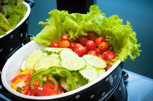 a bowl of lettuce and tomatoes and lettuce lettuce lettuce at Lani Chiang Mai Hotel in Chiang Mai