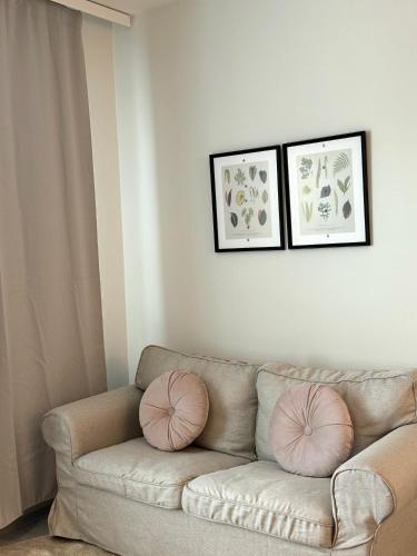 sala de estar con sofá y 2 almohadas rosas en Lux home III, en Tampere