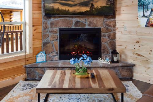 a stone fireplace in a living room with a coffee table at New! Indoor Pool/PS 5/Hot tub/Parkway in Pigeon Forge