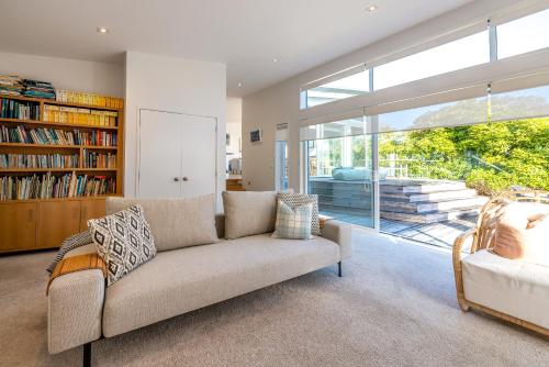a living room with a couch and a large window at Seaviews on Second - 100 metres from Onetangi Beach! - Be My Guest Waiheke in Onetangi