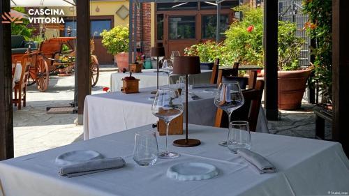 a table with wine glasses and napkins on it at Cascina Vittoria Restaurant Lab & Rooms in Rognano