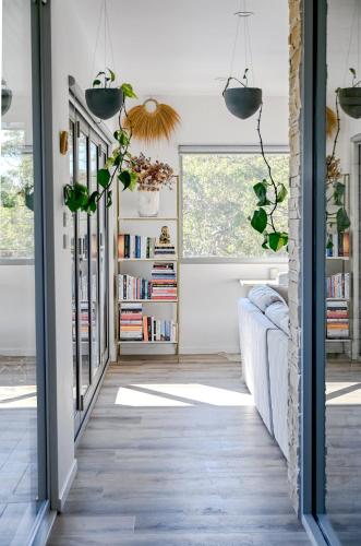 a living room with a couch and a book shelf at The Harmony Retreat in Murrays Beach