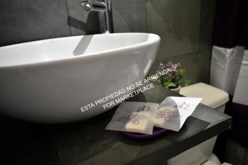 a bathroom with a white sink and two cards on a counter at Piscina Climatizada Privada, Cabaña, Quincho, Limache in Limache