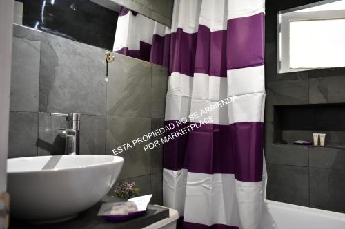 a bathroom with a sink and a shower curtain at Piscina Climatizada Privada, Cabaña, Quincho, Limache in Limache
