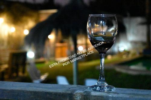 a glass of wine sitting on a table at Piscina Climatizada Privada, Cabaña, Quincho, Limache in Limache