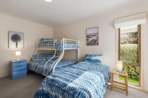 Un dormitorio con dos camas con sábanas azules y blancas. en Lonsdale Back Beach Retreat, en Point Lonsdale