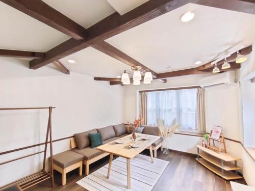 a living room with a couch and a table at 新宿一站 完全独立3层别墅 3室1厅1浴室2卫生间 全新装修 最大12人 near Shinjuku MAX12P in Tokyo
