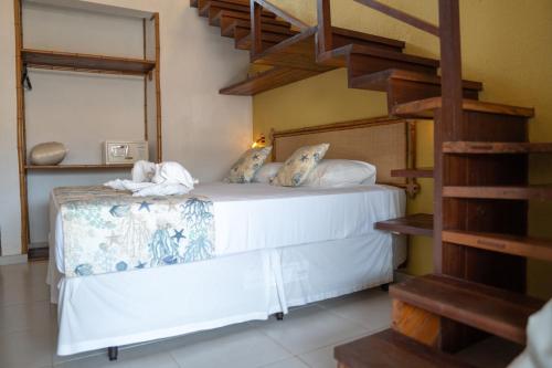 a bedroom with a bed with a spiral staircase at Pousada Sol e Mar in Juquei